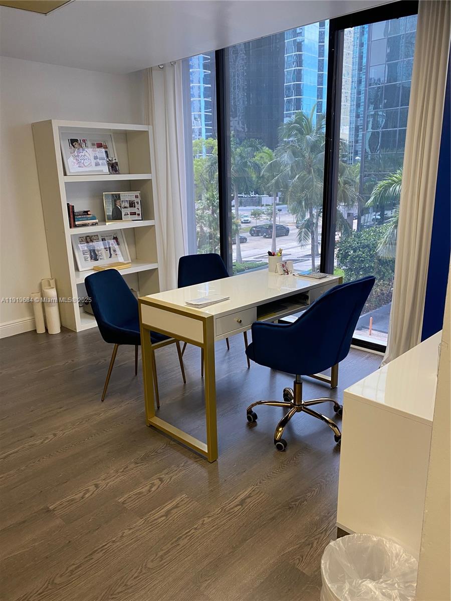 A home office features a white desk, blue velvet chairs, and a bookshelf by windows — 1110 Brickell Ave # 313, Miami FL 33131, MIAMI, FL
