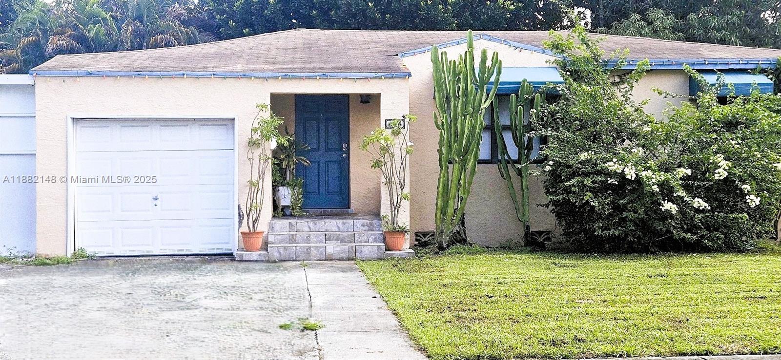 A single-story house features a garage, a blue front door, and large cacti in front — 243 NW 62nd Ct, Miami FL 33126, MIAMI, FL