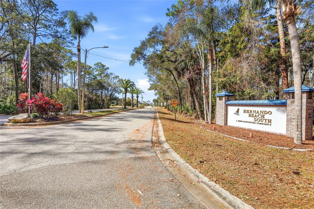 A sign for Hernando Beach South stands beside a paved road lined with trees — 4017 BLUEFISH DRIVE, HERNANDO BEACH, FL