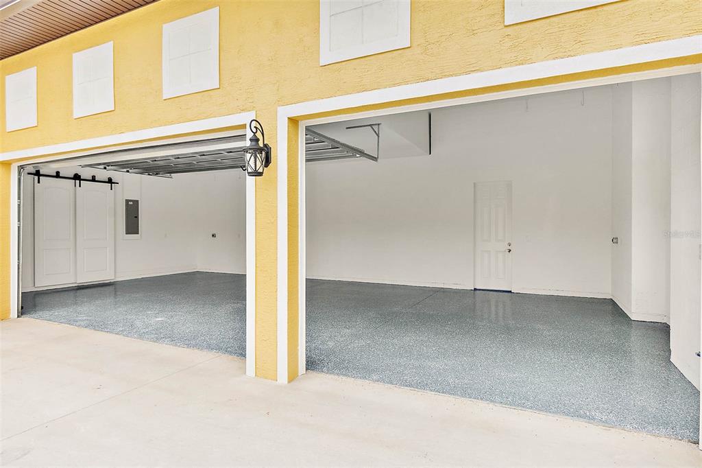 A two-car garage with a speckled epoxy floor and white walls — 3 WHITE HOLLY PLACE, PALM COAST, FL