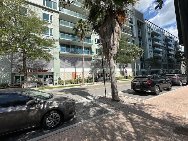 A street-level view shows a multi-story apartment building with ground-floor retail and parked cars — 111 N 12TH STREET UNIT 1620, TAMPA, FL