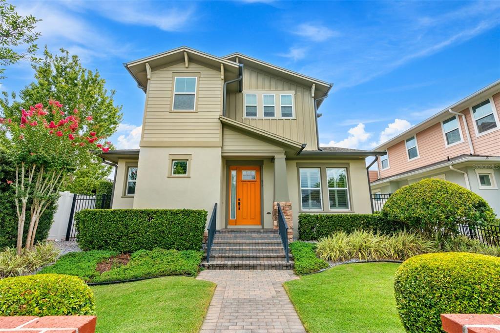 A two-story house with tan siding, an orange front door, and a brick walkway — 437 N CAPEN AVENUE, WINTER PARK, FL