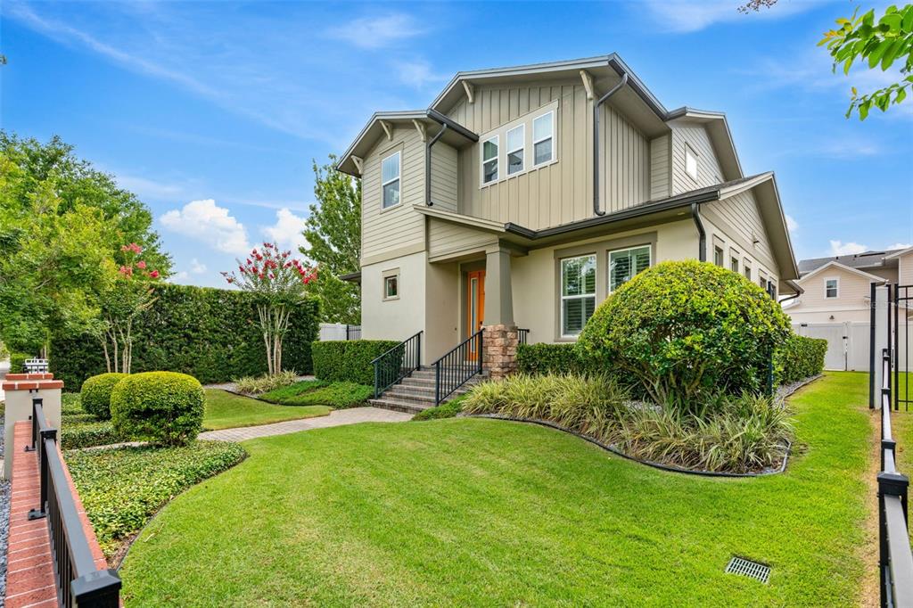 A two-story house with tan siding and a stone-accented front porch entrance — 437 N CAPEN AVENUE, WINTER PARK, FL