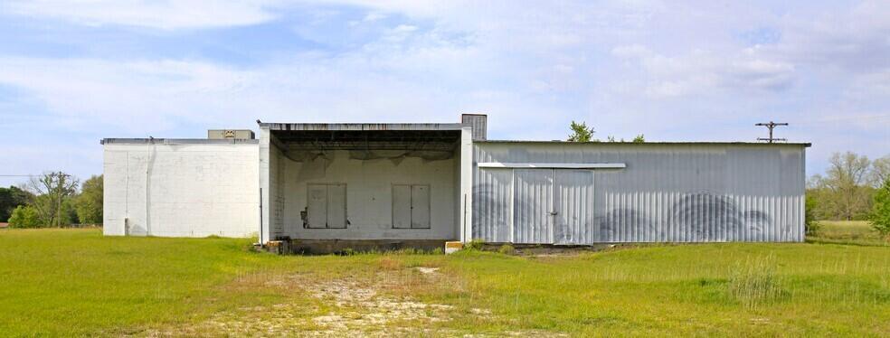 A single-story commercial building with a loading dock sits in a grassy field — 3809 SE County Road 255, FL 32340, FL