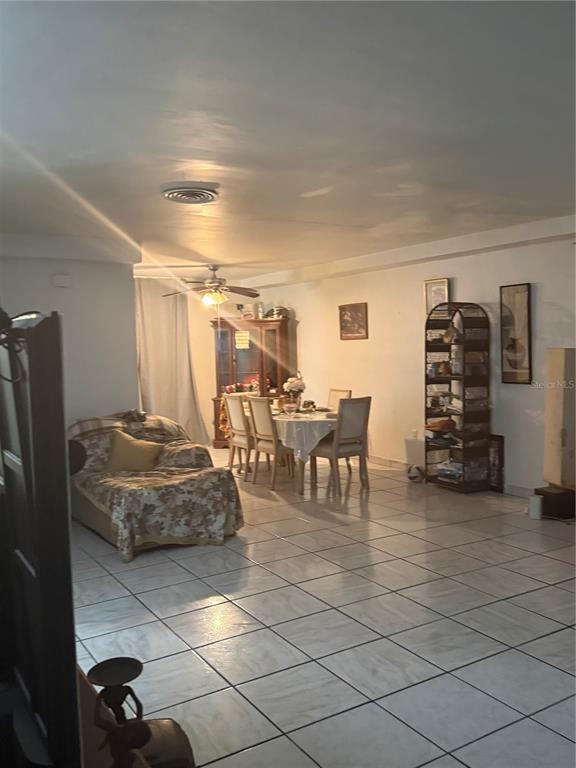 A dining area and living space with tiled floors, a ceiling fan, and a hutch — 7350 GARY AVENUE, MIAMI BEACH, FL