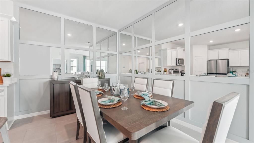 A dining room features a wooden table, white chairs, and a wall of decorative mirrors — 33042 RUSTIC RISE ROAD, SAN ANTONIO, FL