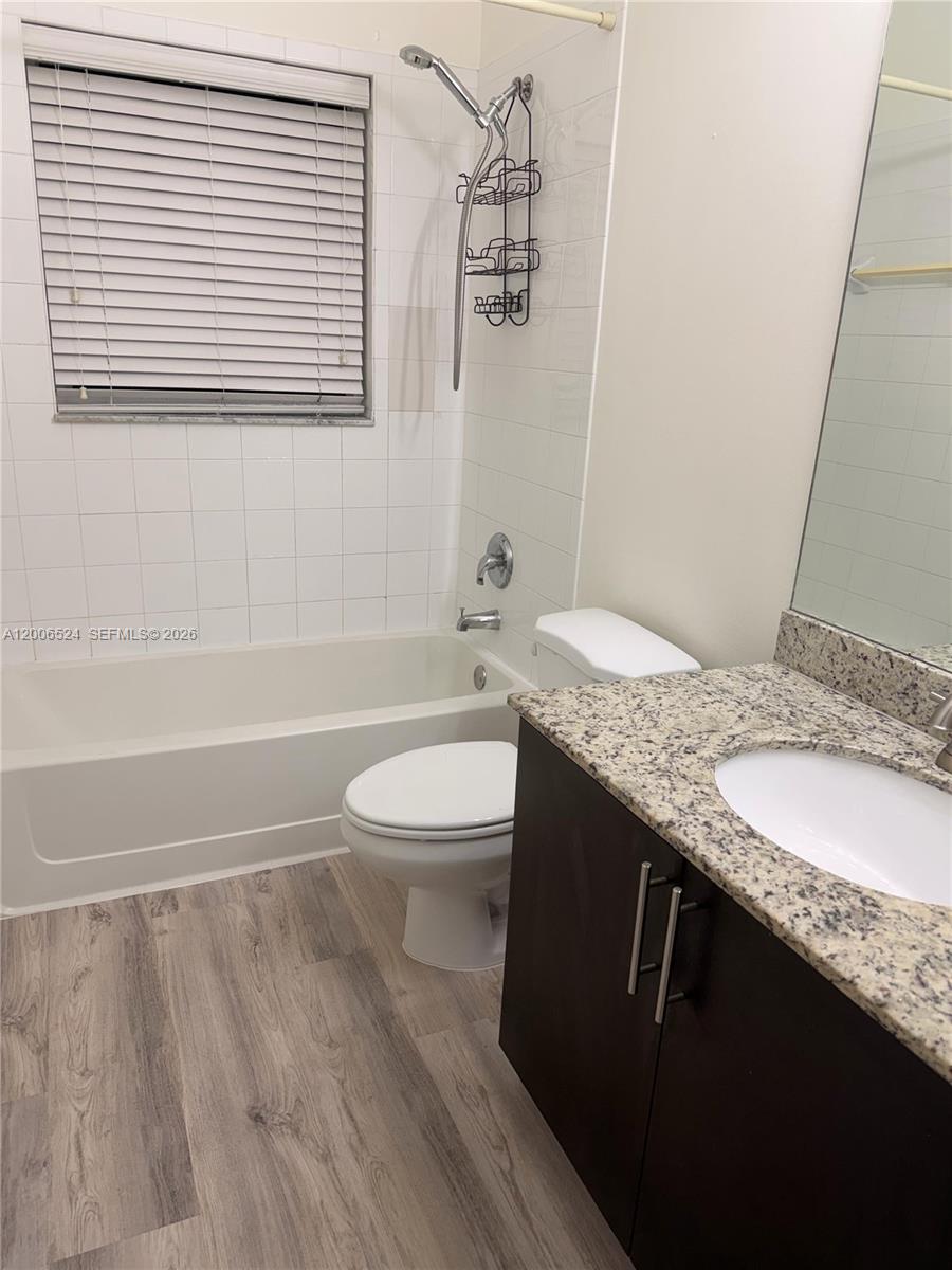 A bathroom features a bathtub-shower combination, a toilet, and a granite-topped vanity — 9040 NW 54th St, Sunrise FL 33351, SUNRISE, FL