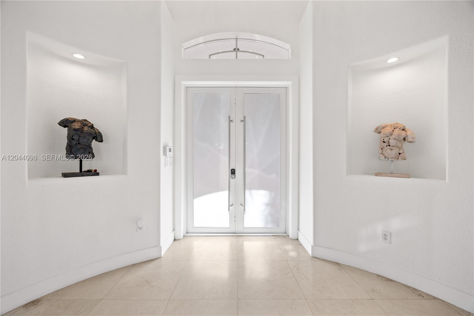A bright entryway features double glass doors, tiled floors, and two recessed wall niches — 12235 SW 121st Ter, Miami FL 33186, MIAMI, FL