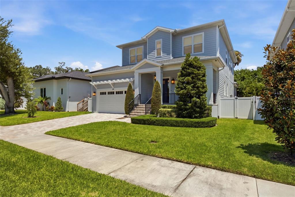 A two-story light blue house with a white garage and a manicured front lawn — 210 S SHORE CREST DRIVE, TAMPA, FL