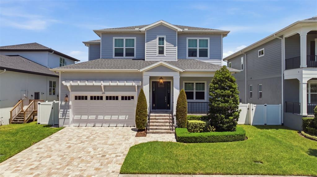 A two-story blue house with a paved driveway, a front porch, and a garage — 210 S SHORE CREST DRIVE, TAMPA, FL