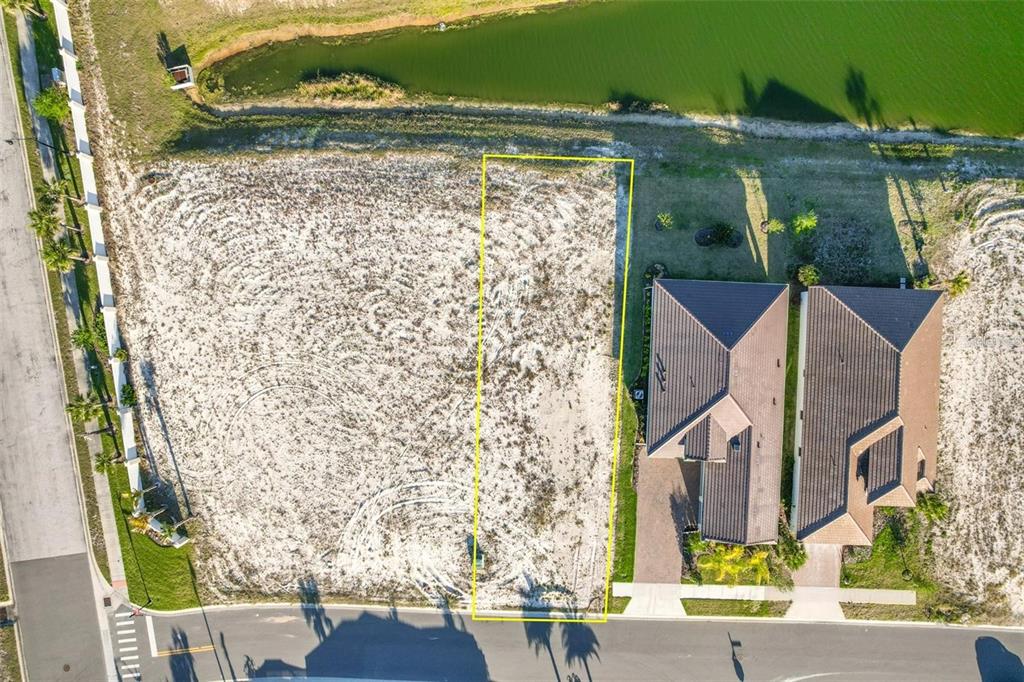 An aerial view shows a vacant rectangular residential lot outlined in yellow next to a house — 130 DEL PALMA DRIVE, PALM COAST, FL