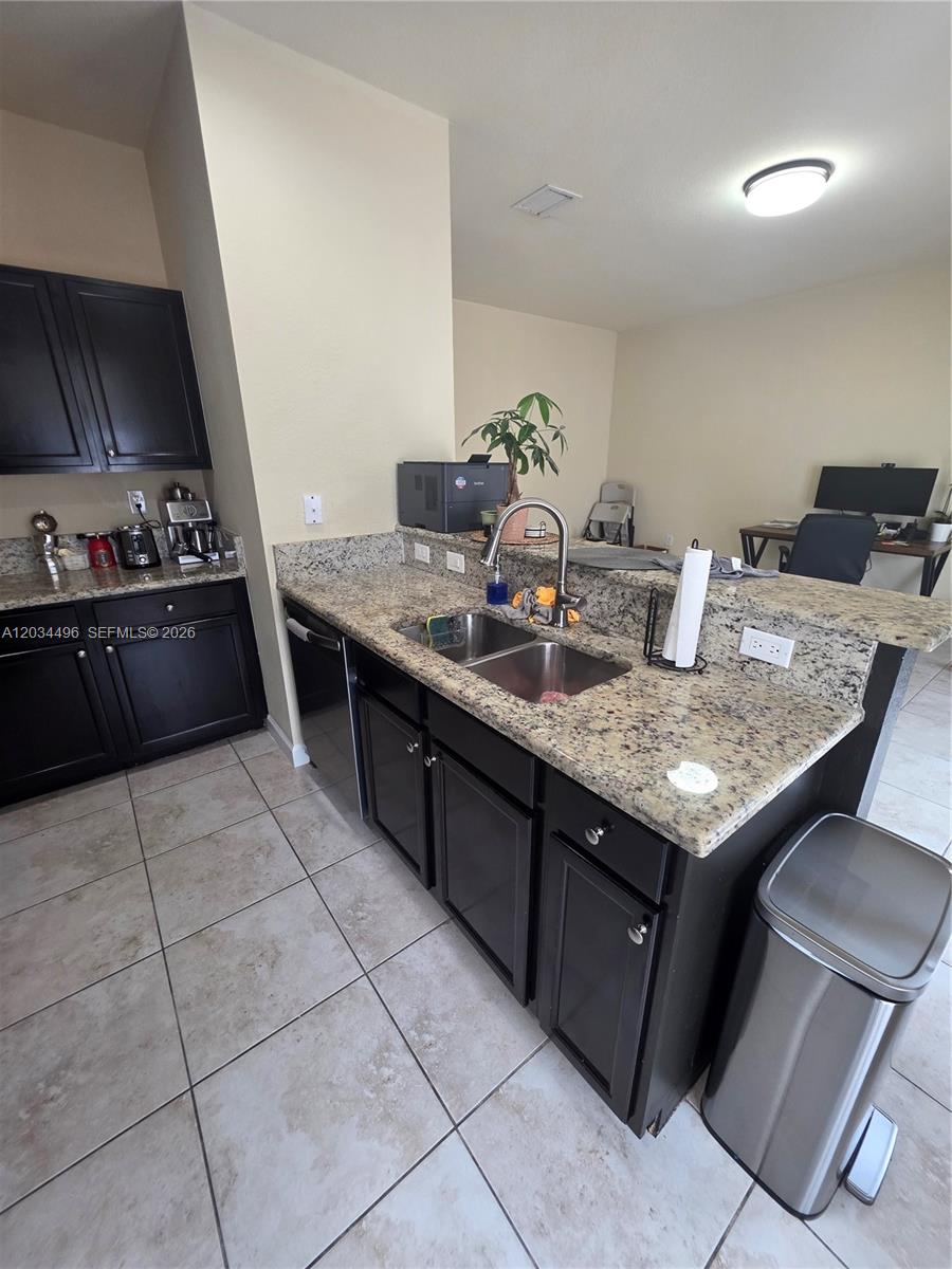 A kitchen features dark cabinets, granite countertops, a double sink, and tile flooring — 9424 SW 171st Pl, Miami FL 33196, MIAMI, FL