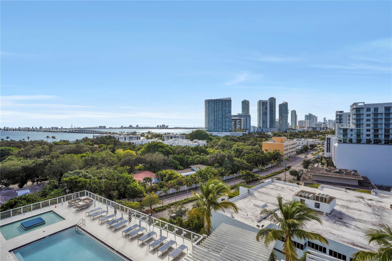 An elevated view of a swimming pool deck overlooking a city skyline and the ocean — 4250 Biscayne Blvd # 1116, Miami FL 33137, MIAMI, FL