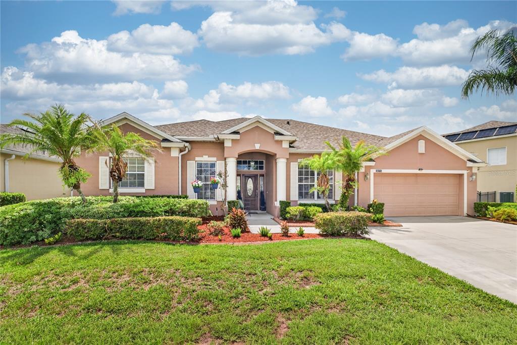 A screened-in pool area features a spa, a tanning ledge with chairs, and stone pavers — 10174 MALLARD LANDINGS WAY, ORLANDO, FL