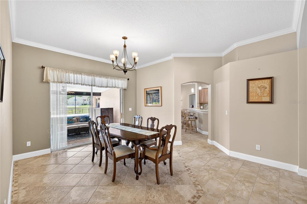 A dining room with tile floors, a wooden table, and a sliding glass door — 10174 MALLARD LANDINGS WAY, ORLANDO, FL