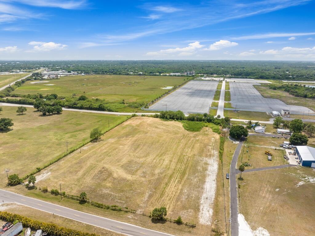 An aerial view shows a large, vacant grassy lot bordered by a road and trees — 3274 NW 18th Street, Okeechobee FL 34972, OKEECHOBEE, FL