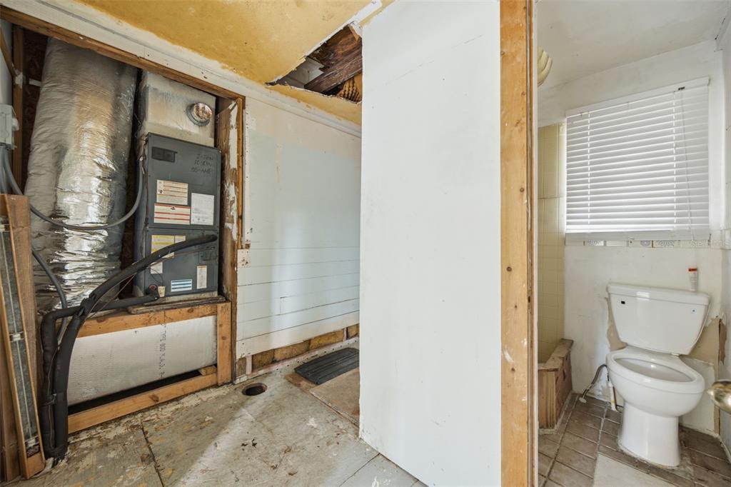 A utility room with an exposed HVAC unit and a small adjacent bathroom with a toilet — 307 W ALFRED STREET, TAMPA, FL