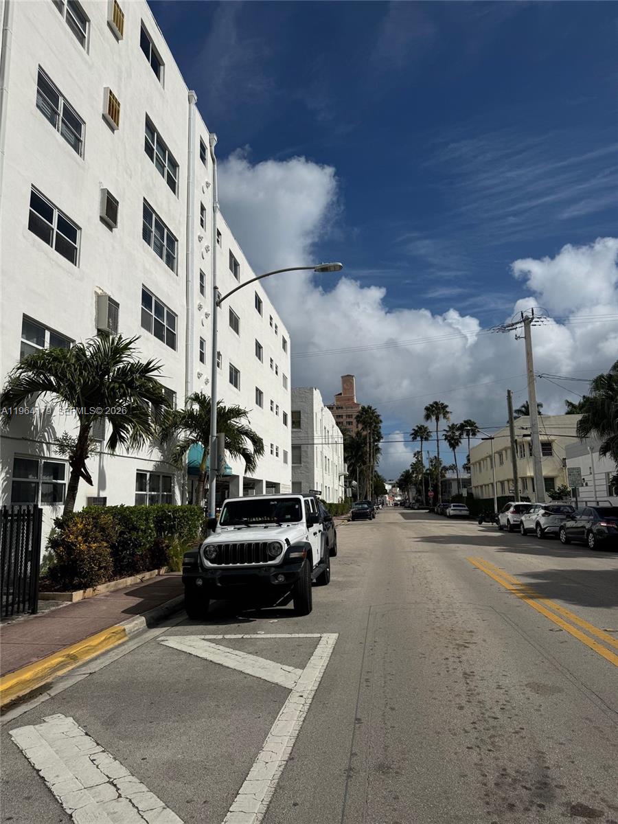 A white Jeep is parked on a street next to a multi-story white apartment building — 801 Meridian Ave # 3B, Miami Beach FL 33139, MIAMI BEACH, FL