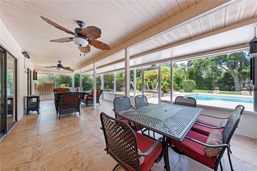 A covered patio features tile flooring, ceiling fans, outdoor furniture, and a view of a pool — 2440 CRANE COURT, ST CLOUD, FL