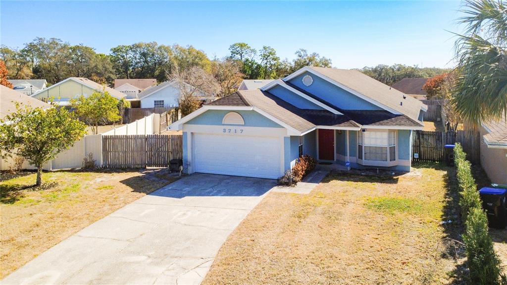 A single-story house with a two-car garage, light blue siding, and a concrete driveway — 3717 NARROLINE DRIVE, ORLANDO, FL