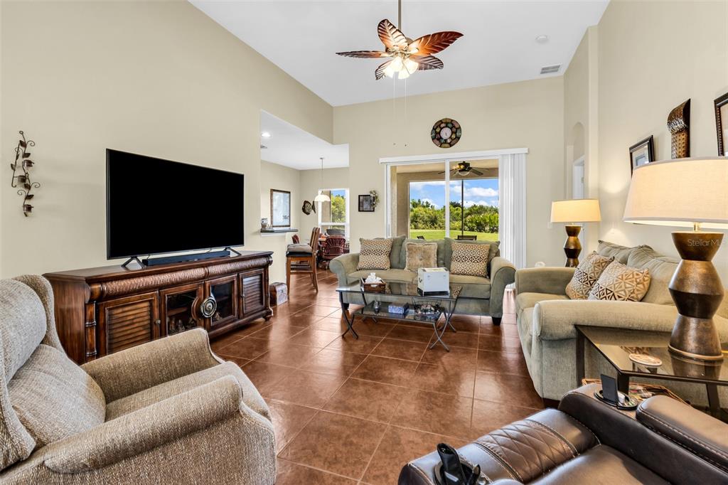 A living room features tile floors, a ceiling fan, and a view of the backyard — 24376 WESTGATE BOULEVARD, PUNTA GORDA, FL