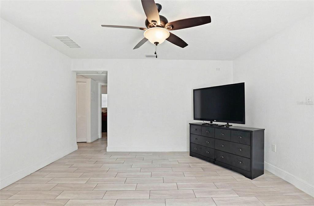 A room with white walls, light tile flooring, a ceiling fan, and a black dresser — 2521 W CREST AVENUE, TAMPA, FL