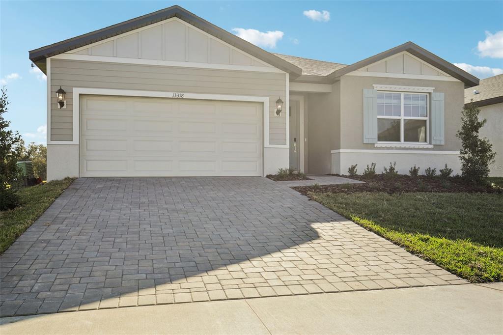 A single-story suburban house features a paved driveway, a two-car garage, and light-colored siding — 13318 SHELLMORE AVENUE, PALMETTO, FL