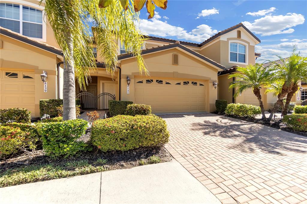A two-story tan stucco house with a paved driveway and a two-car garage — 8141 MIRAMAR WAY UNIT 8141, LAKEWOOD RANCH, FL