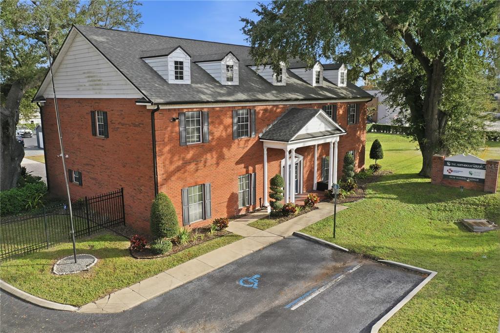 An aerial view shows a two-story brick office building with a white-pillared entrance and dormers — 5639 HANSEL AVENUE, ORLANDO, FL
