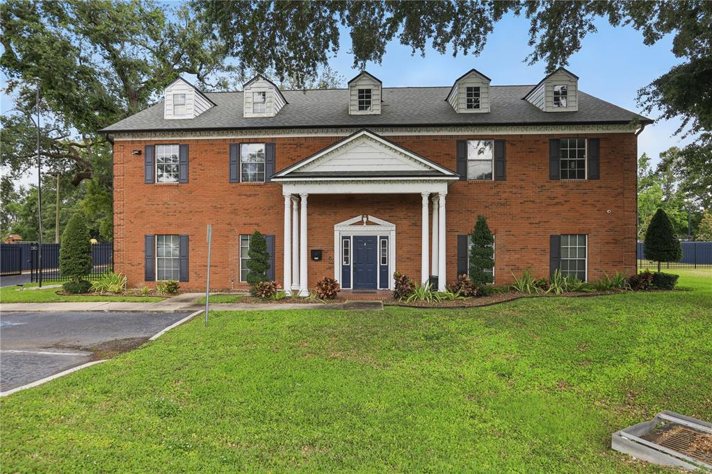 A two-story brick building features a central portico, dark blue shutters, and five roof dormers — 5639 HANSEL AVENUE, ORLANDO, FL