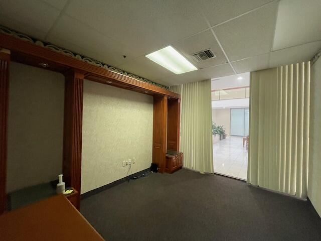 An office space features dark carpeting, wood-paneled wall units, and vertical blinds covering a doorway — 631 Us-1 # 101, North Palm Beach FL 33408, NORTH PALM BEACH, FL