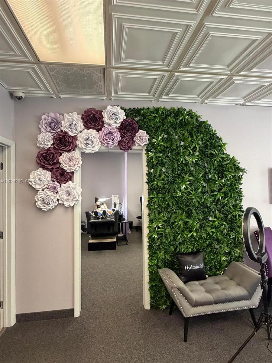 A doorway is decorated with large paper flowers and a vertical green wall — 2700-2750 N 29th Ave # 103, Hollywood FL 33020, HOLLYWOOD, FL