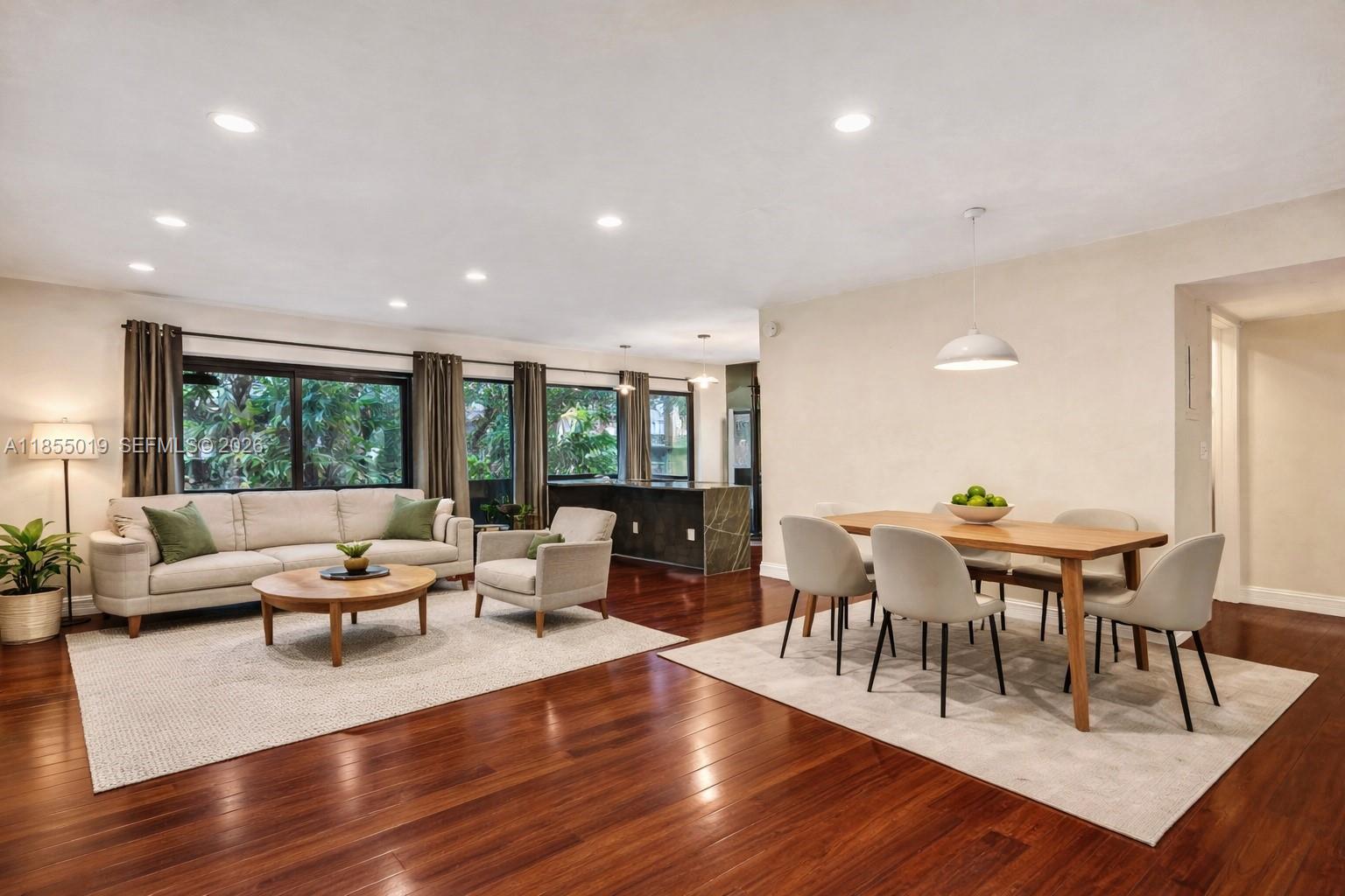 An open-concept living and dining area features hardwood floors, recessed lighting, and large windows — 3621 Lime Hill Rd # 202, Lauderhill FL 33319, LAUDERHILL, FL
