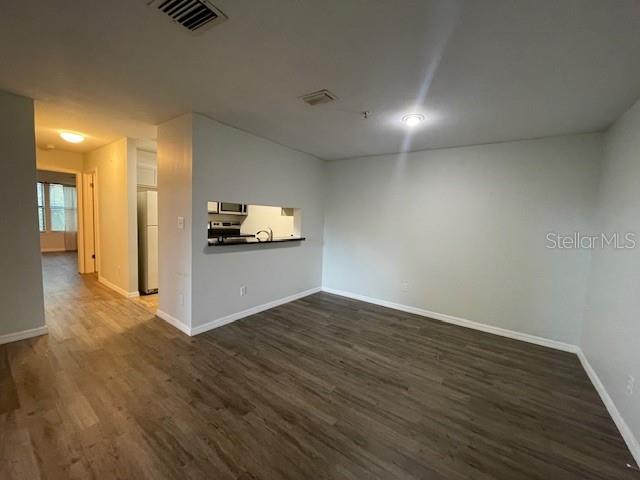 An open living area features wood-look flooring and a kitchen pass-through window — 4028 CROCKERS LAKE BOULEVARD UNIT 11, SARASOTA, FL