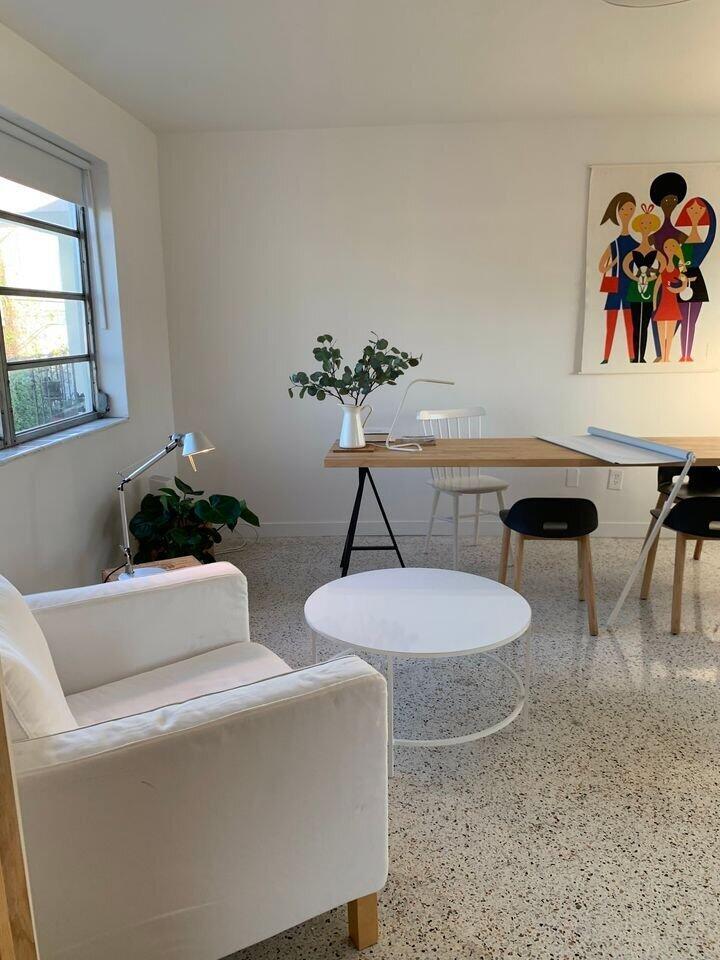 A bright room features a white armchair, a round coffee table, and a wooden desk — 649 SW 9th Street # 301, Miami FL 33130, MIAMI, FL