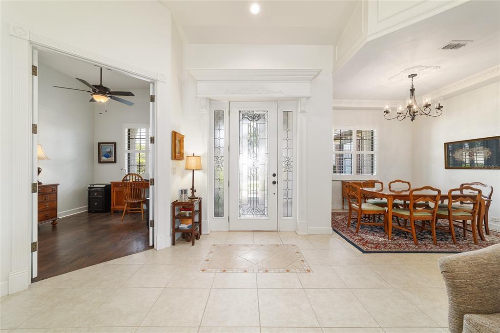 An entryway with tile flooring, a glass-paneled front door, a home office, and a dining room — 2806 SE 30TH STREET, OCALA, FL