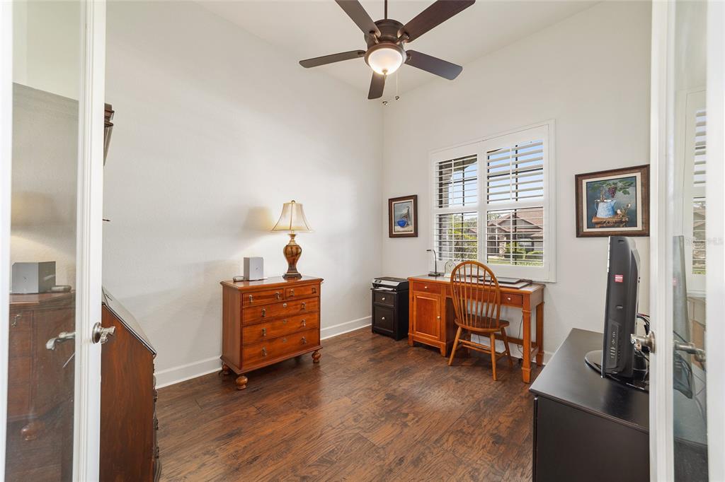 A home office features wood flooring, a ceiling fan, a desk, and a wooden dresser — 2806 SE 30TH STREET, OCALA, FL