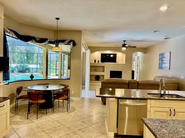 An open-concept kitchen and dining area features a breakfast bar, tile flooring, and pool views — 22444 OAKVILLE DRIVE, LAND O LAKES, FL