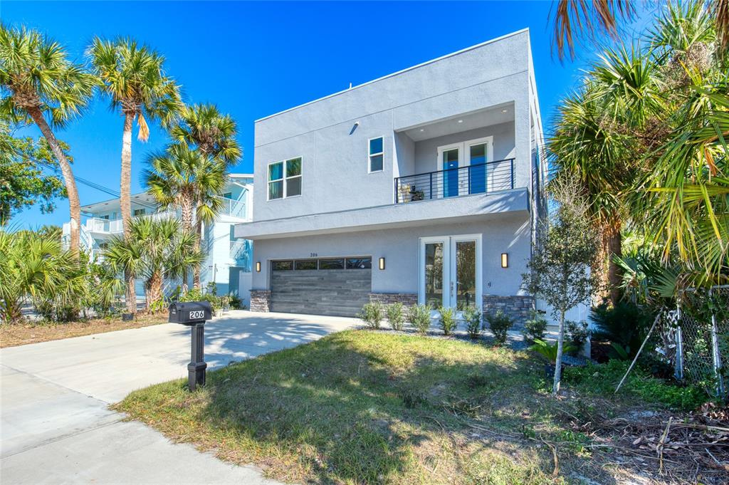 A modern two-story house with a gray exterior, a balcony, and a two-car garage — 206 N HALIFAX AVENUE, DAYTONA BEACH, FL