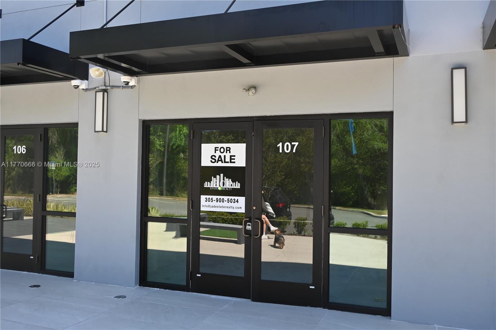 The exterior of a commercial building features two glass entry doors labeled 106 and 107 — 3370 ROUSE RD # 107, Orlando FL 32819, ORLANDO, FL
