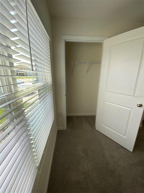 A room features carpeted flooring, a window with white blinds, and an open closet door — 4961 SW 88TH PLACE, OCALA, FL