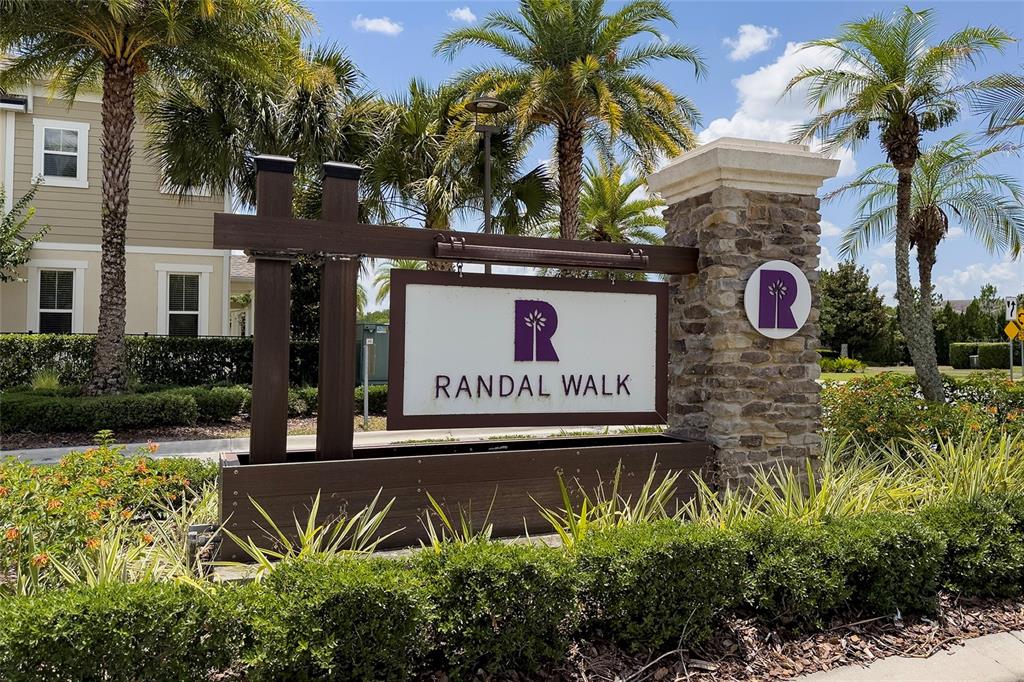 A stone and wood sign for Randal Walk stands in front of palm trees — 10239 HIGHLINE CREST STREET, ORLANDO, FL