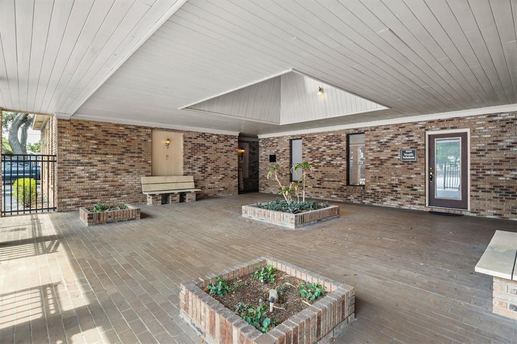 An outdoor covered patio features brick flooring, brick planters, and a central skylight — 4945 SOUTHFORK DRIVE, LAKELAND, FL