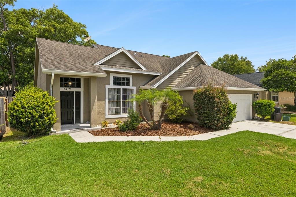 A single-story house with a tan stucco exterior, a dark roof, and a front lawn — 1513 OBERLIN TERRACE, LAKE MARY, FL