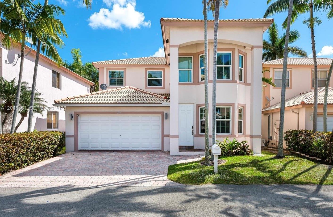 A two-story, light-colored stucco house with a two-car garage and a paved driveway — 208 SE 15th St, Dania Beach FL 33004, DANIA BEACH, FL