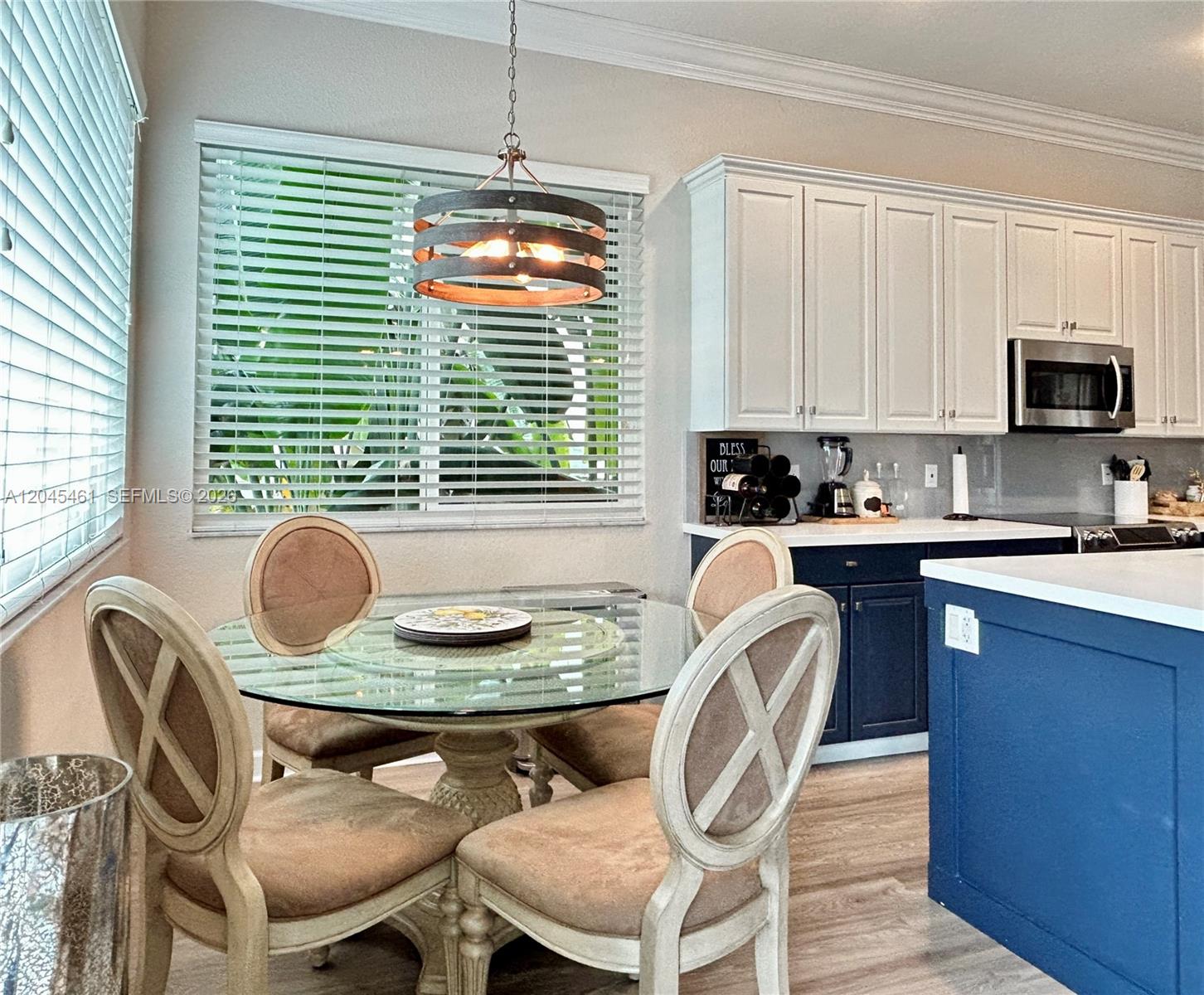 A dining area features a glass table, four chairs, and a rustic chandelier near cabinets — 208 SE 15th St, Dania Beach FL 33004, DANIA BEACH, FL