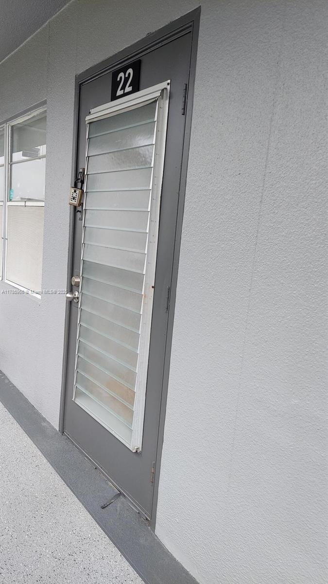A gray exterior door labeled 22 features a louvered glass window and a padlock — 22 Suffolk A # 22, Boca Raton FL 33434, BOCA RATON, FL