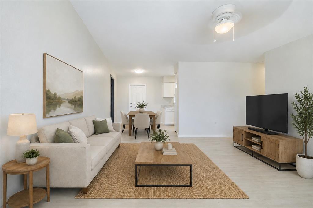 A living room features a beige sofa, wooden coffee table, television console, and dining area — 2112 EMBRY AVENUE, HAINES CITY, FL