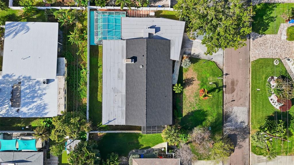 An aerial view shows a house with a dark roof, a pool, and a grassy yard — 3944 49TH AVENUE S, ST PETERSBURG, FL