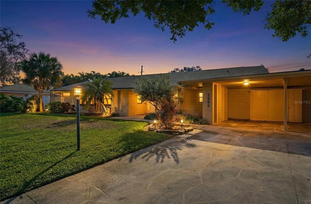 A single-story house with a concrete driveway and carport at twilight — 3944 49TH AVENUE S, ST PETERSBURG, FL